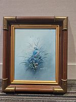 Front view of original blue bird oil painting in bamboo-style frame.