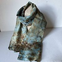 Full view of silk scarf draped on mannequin showing overall design and colors.