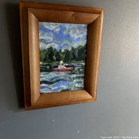 Framed original oil painting of a canoe on a lake with trees and a cloudy sky