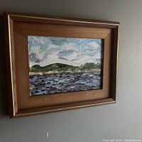 Frontal view of the framed oil painting on the wall showing the entire artwork and frame.