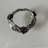 Top view of the sterling silver bracelet showing roses and leaves linked in a bracelet form.