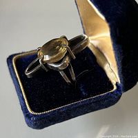 Handmade sterling silver ring with oval citrine stone in modernist setting inside a blue velvet lined box.