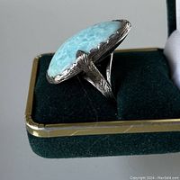 Side view of the sterling silver larimer stone ring showing feather etching on the band and setting edges.