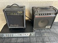 Two guitar amps and the Digidesign Digi 002 rack interface on a table against a cinder block wall.