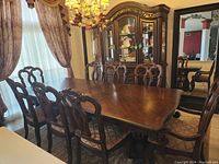 Dining table and eight chairs positioned before matching china cabinet