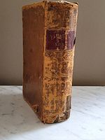 Front spine view showing the leather cover with a red label embossed 'PRACTICAL NAVIGATION' and visible wear and tear.