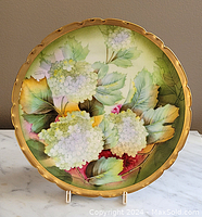 Front view of the hand painted decorative plate showing full floral design and gold scalloped rim.