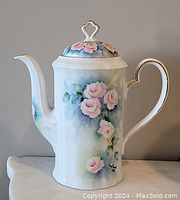 Front view of hand painted porcelain tea pot with pink roses and gold accents on spout and handle.