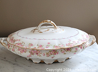 Side angle showing the floral pattern and gold detailing on the tureen body and lid handle.