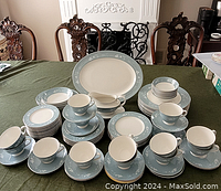 Full set arranged on table showing cups, saucers, bowls, plates, platter, and gravy boat
