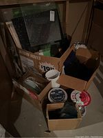 Boxes filled with stained glass sheets, assorted glass pieces, and packaging materials.