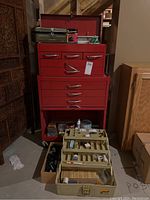 Photo of the red metal tool chest with multiple drawers and the beige plastic compartment organizer open in front containing craft and small hardware supplies.
