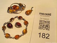 Photo showing bracelet, brooch, and earrings with auction card. Bracelet and earrings marked 925, brooch unmarked.