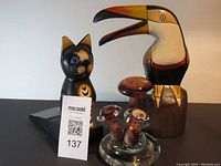 Front view of the three figurines with lot card for scale