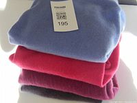 Stack of four cashmere sweaters showing colors and general condition.