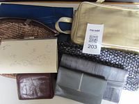 Seven evening bags and wallets arranged to show variety of colors, textures and materials including leather and fabric