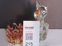 Murano glass dog figurine and ruffled-edge bowl shown side by side with auction card