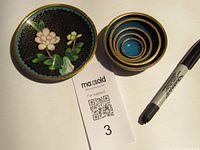 Overview photo showing the small cloisonne plate and the set of five nesting bowls, pen included for scale