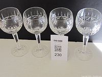 Set of four Waterford large wine glasses with the Colleen cut crystal pattern shown from front view.
