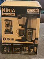 Sealed Ninja Coffee Bar Auto-iQ box showing front packaging with product image and description.