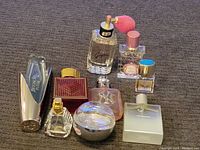 Overall shot of the nine assorted perfume and cologne bottles on a brown carpet.