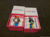 Wide view of both watches in pink Limited Too boxes showing the unicorn design and mood color changing watch text on packaging.