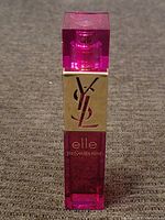 Front view of the Yves Saint Laurent Elle perfume bottle showing pink translucent bottle with gold YSL logo and spray nozzle.