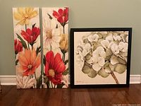 Three floral wall art pieces: two vertical painted panels and one framed print with white hydrangea flowers.