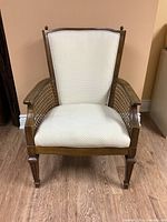 Front view of wood frame chair showing white upholstered seat and back with cane arms and tapered legs.