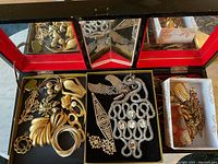 Overhead view of three central compartments with gold-tone bangles, brooches and silver-tone rhinestone pieces