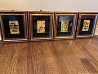 Four framed Italian art pieces arranged side by side on a floor