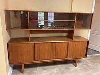 Full front view of two-piece cabinet showing lower storage base and upper glass hutch