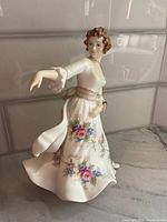 Front side of the Royal Doulton Hazel porcelain figurine showing detailed floral patterns and flowing dress.