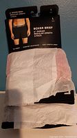 Three-pack of American Eagle boxer briefs in black wrapped in tissue paper with retail packaging.