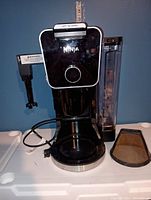 Front view of the black Ninja Dual Brew Pro coffee maker showing the control dial and water reservoir.