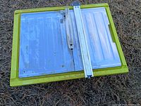 Full view of the Ryobi tile saw showing the cutting surface, sliding table, and yellow plastic base.