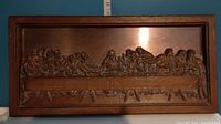 Full view of copper plaque depicting The Last Supper, framed in wood.