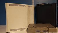 Original Sony PlayStation console shown from top and front views against blue background