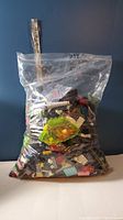 First plastic bag containing assorted LEGO pieces with visible variety of colors and shapes.