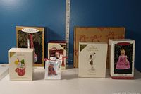 Photo of six Hallmark Christmas ornaments in original boxes arranged on a surface with a ruler behind for scale.
