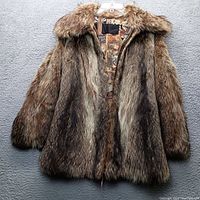 Front view of the brown fur coat showing various brown shades with black streaks and fluffy collar.