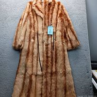 Front view of the long fur coat showing the full length and striped fur pattern.