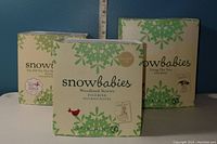 Three original boxes of Department 56 Snowbabies figurines with labels visible: Elf On The Shelf, Woodland Stories, Totting The Tree