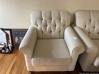 Two ivory upholstered armchairs side by side