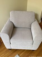 Front view of light beige upholstered armchair