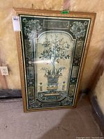 Full photo of framed inlaid marble style print depicting plant in decorative pot and ornamental details.