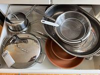 Overview of pots, pans, large mixing bowl, steamer inserts, and terracotta pans in drawer.