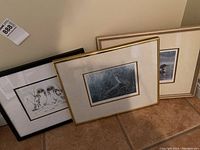 Three framed wildlife prints leaning against wall showcasing the lot contents.