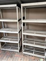 Full view of two white 5-tier plastic shelving units side by side.
