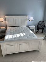 Full view of bed with wooden frame, headboard, footboard and mattress included, showing the design and condition.